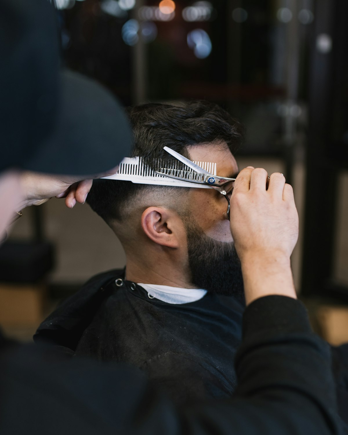 Barber giving a precision scissor cut